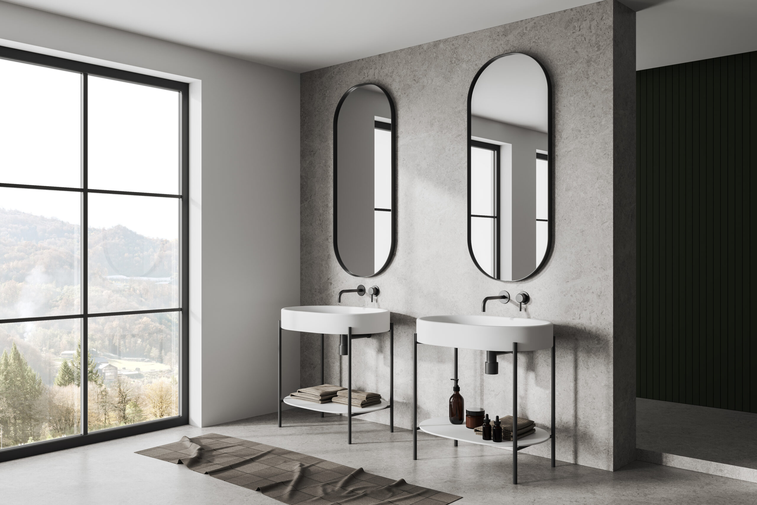 Corner of modern bathroom with white and concrete walls, concrete floor, double sink with two oval mirrors and window with mountain view